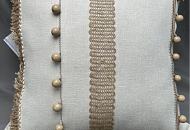 Декоративная подушка из мелкой рогожки, украшенная джутовыми басонными изделиями и бахромой с деревянными шариками.